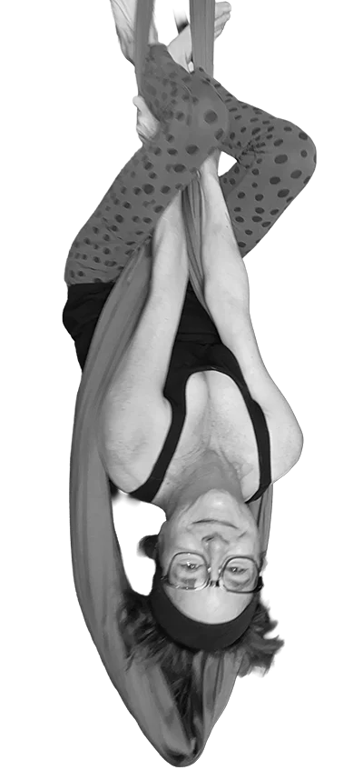 Alyx dangling upside down in the air doing an awesome aerial arts move